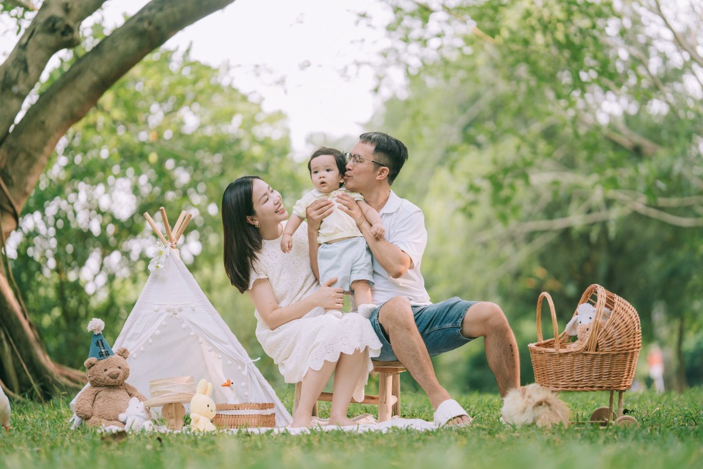 Bố mẹ và bé picnic bên lều trắng trên bãi cỏ